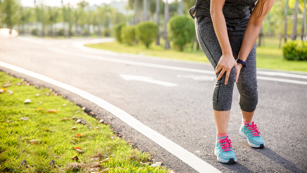 woman with sore muscle running