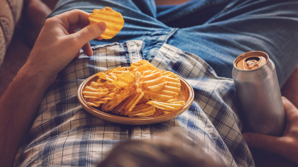 man laying down eating junk food