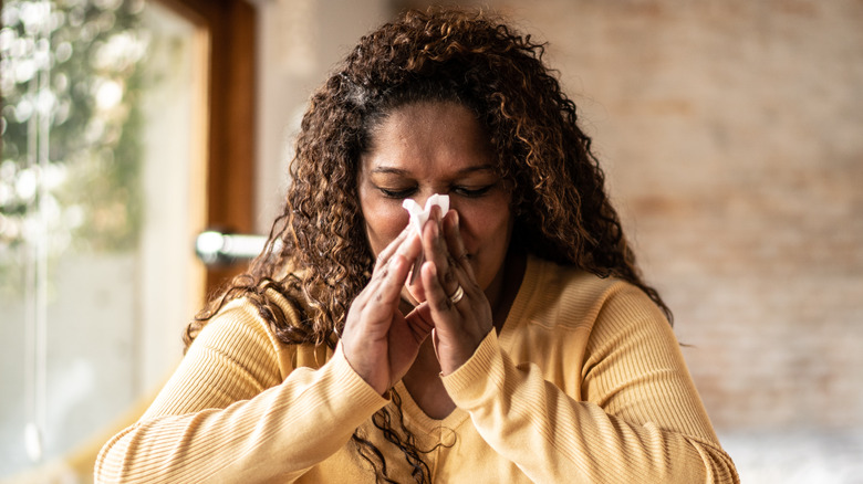 Woman blowing nose