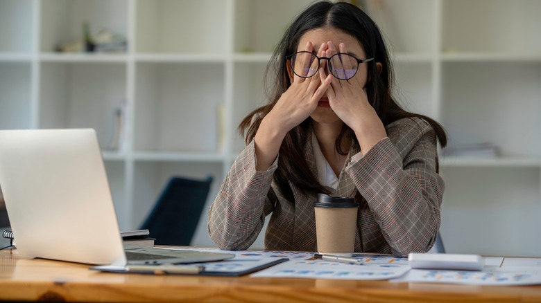 Business woman holding head in hands