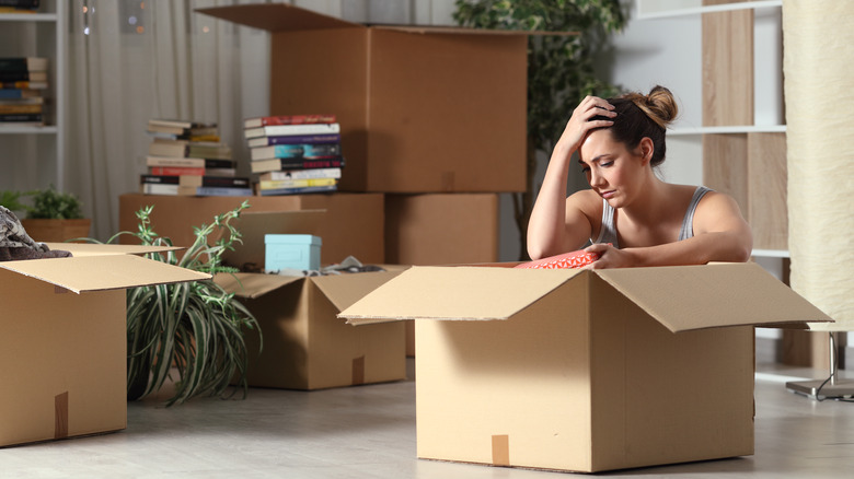 a woman sits in moving box