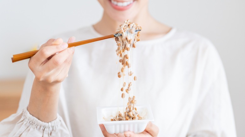 woman holding natto with chopsticks