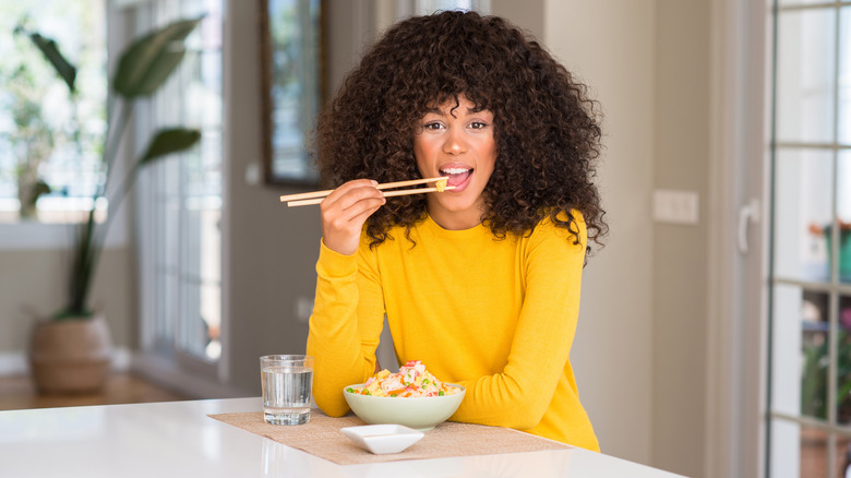 woman eating a rice dish