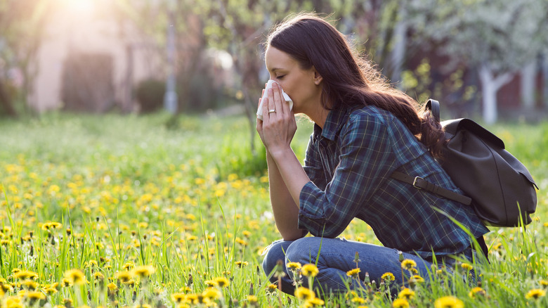 woman with allergies blowing her nose