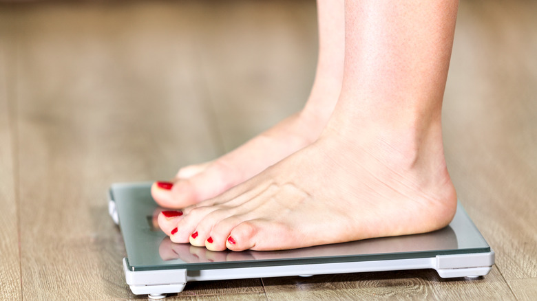 woman stepping on scale