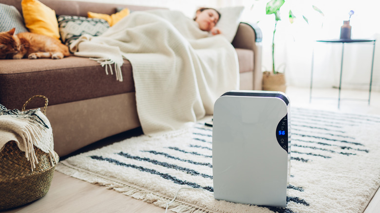 Woman sleeping near dehumidifier 