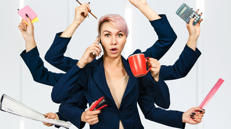 stressed out woman holding multiple office items
