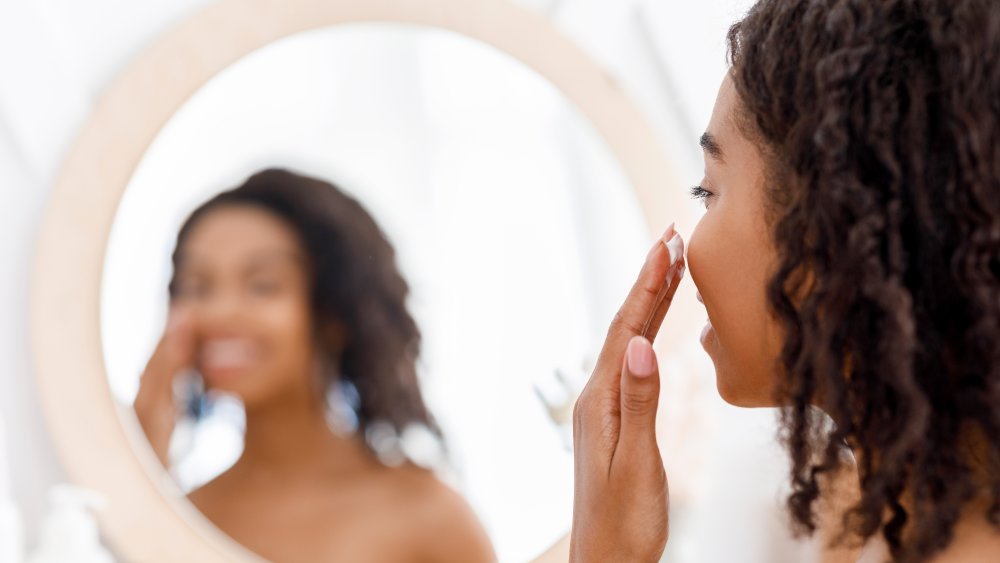 Black woman looking in mirror