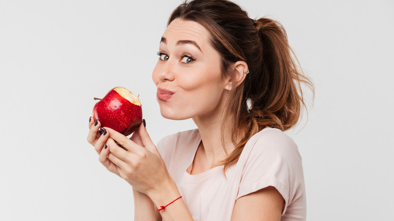 Woman with mouthful of apple