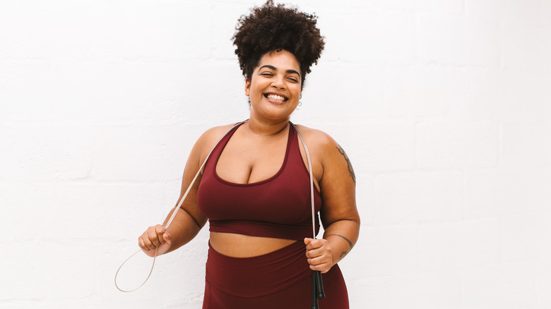 a woman smiling with a jump rope around her neck