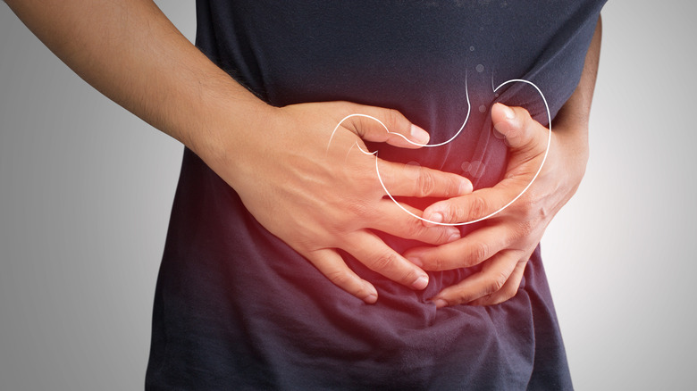 Close up of man holding his inflamed stomach