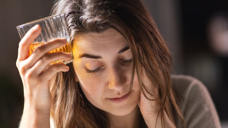 Woman drinking alcohol and looking ill