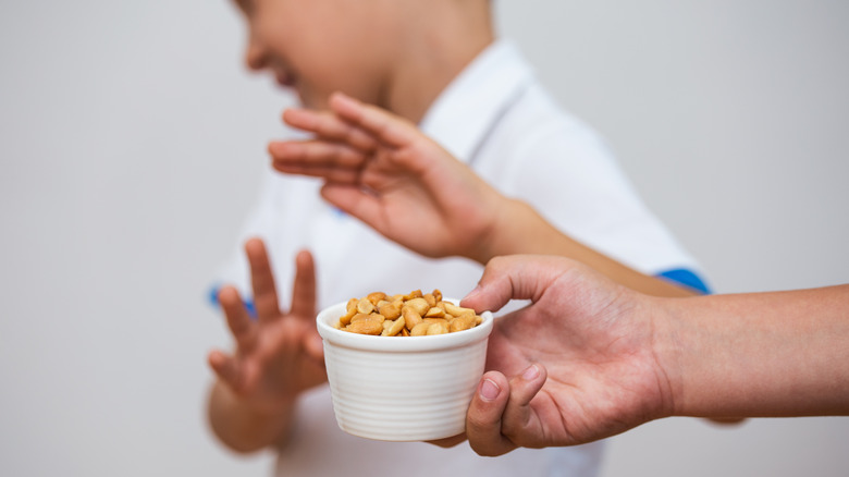 person avoiding a cup of nuts