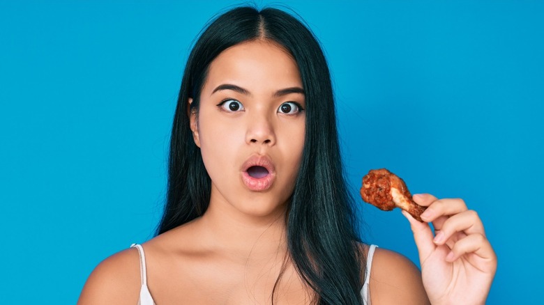 woman eating spicy chicken wing
