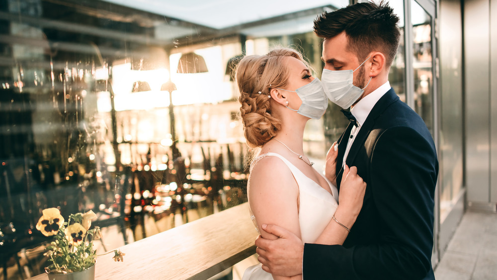 Young couple getting married with masks on
