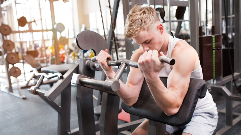 A man using a bicep curl machine