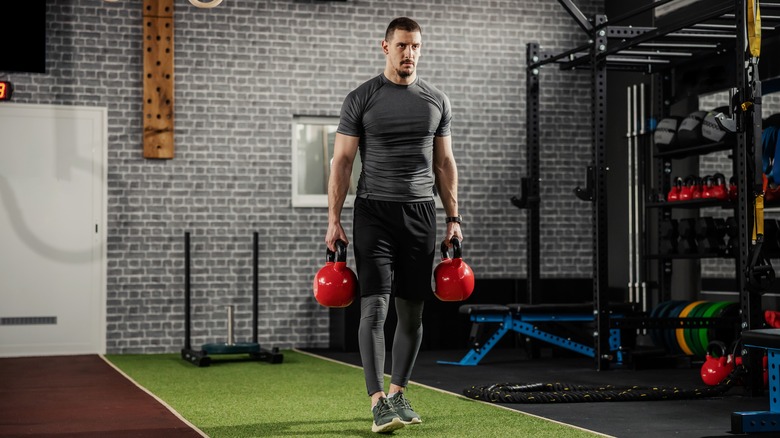 a man carrying weights and walking