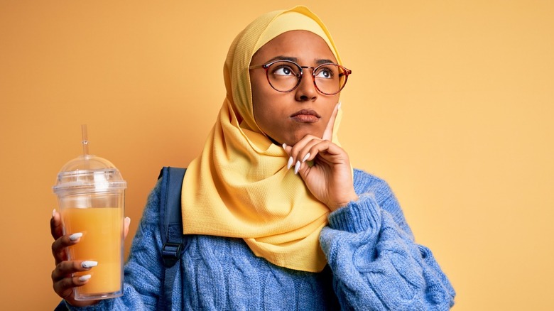 woman holding orange juice