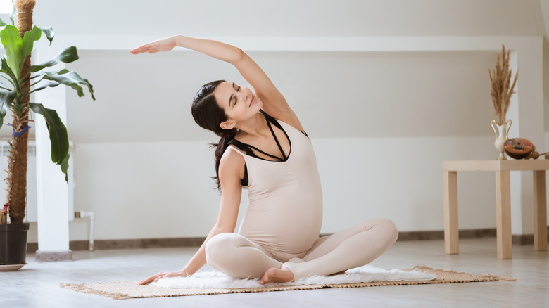 Pregnant woman doing a side stretch
