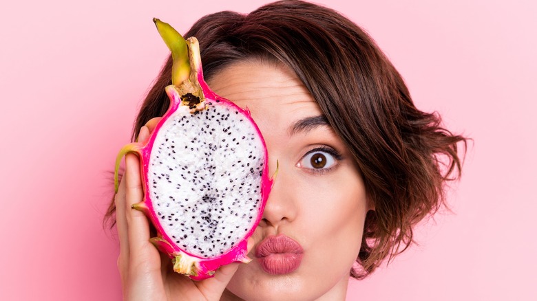 woman holding dragon fruit