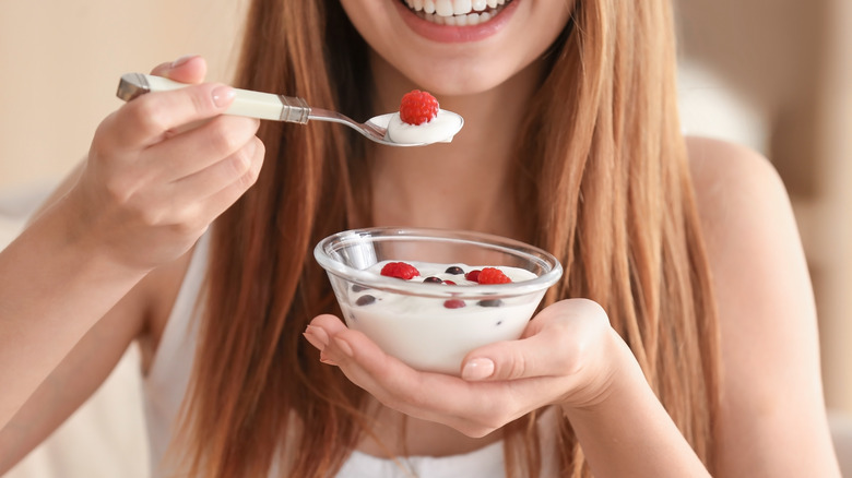 woman eating yogurt with berries