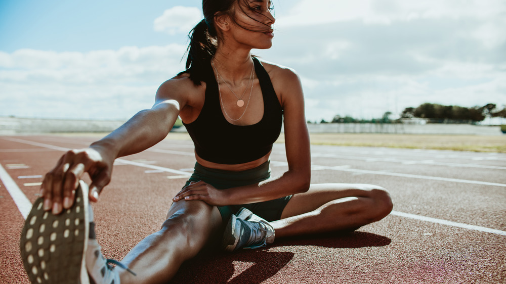 Woman stretching on running track