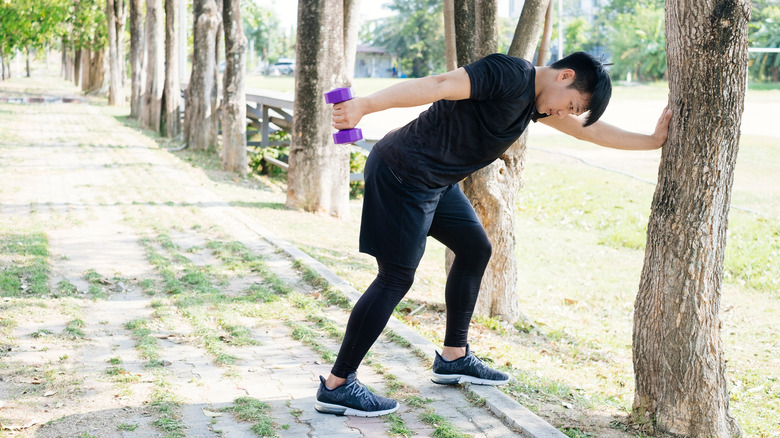 A man performs a tricep kickback