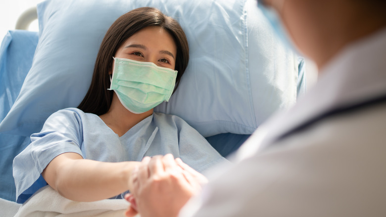 A young female patient lies in a hospital bed