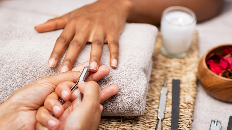 Hand getting nails clipped at salon
