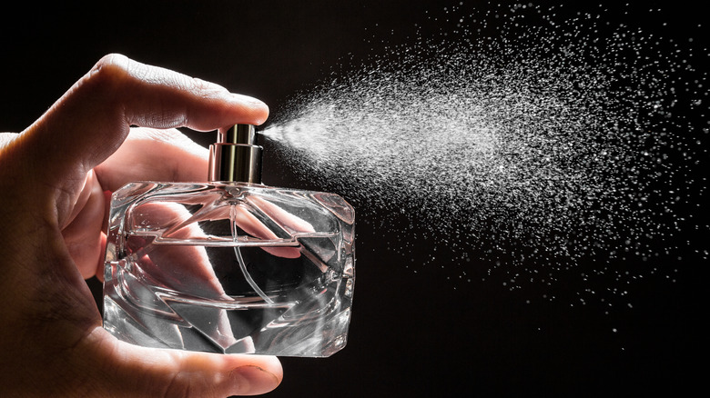 Hand spraying perfume bottle