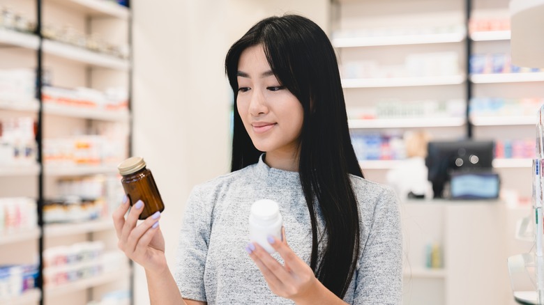 woman looking at antibiotic bottles