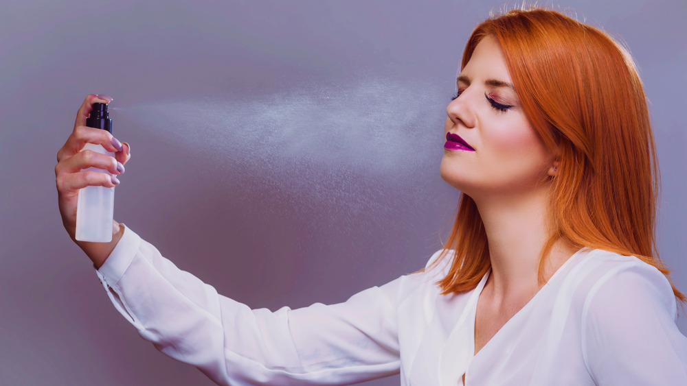 Woman applying makeup setting spray