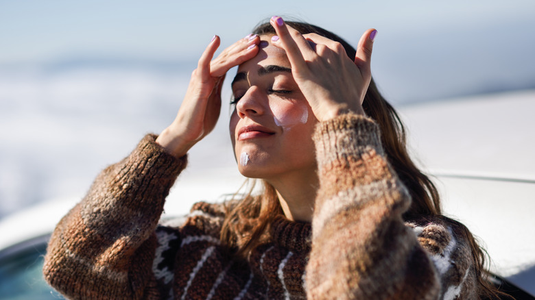 Woman putting on sunscreen