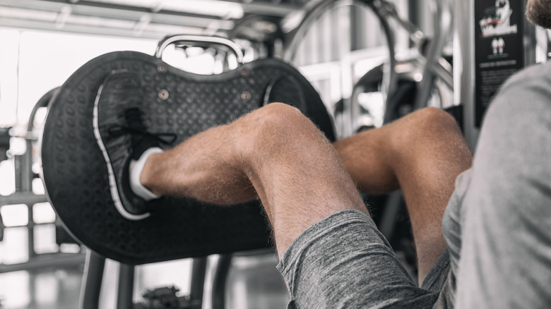 muscular legs using leg press machine