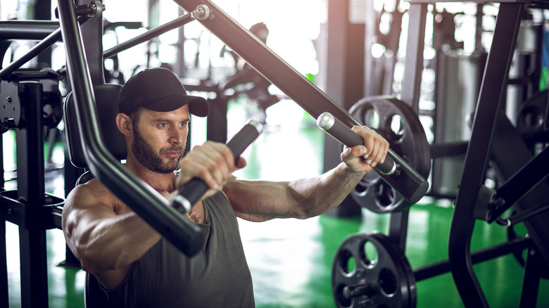 Fit man using the seated bench press machine