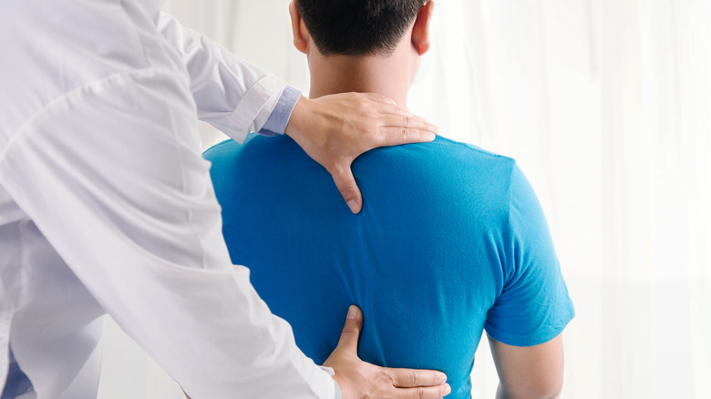 Doctor working with man's back