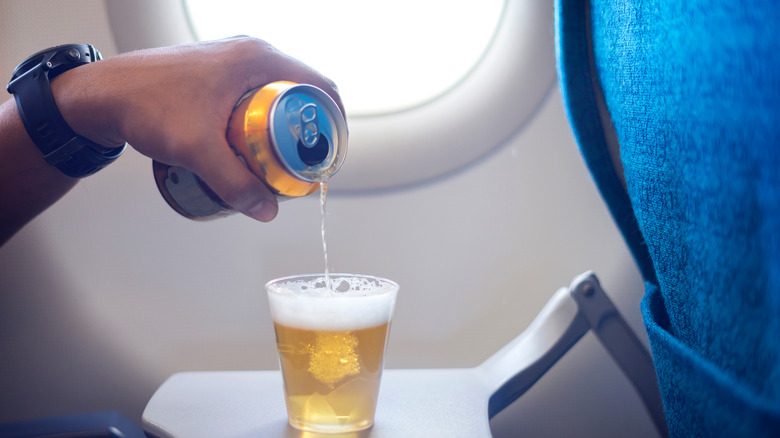 Hand pouring beer on plane
