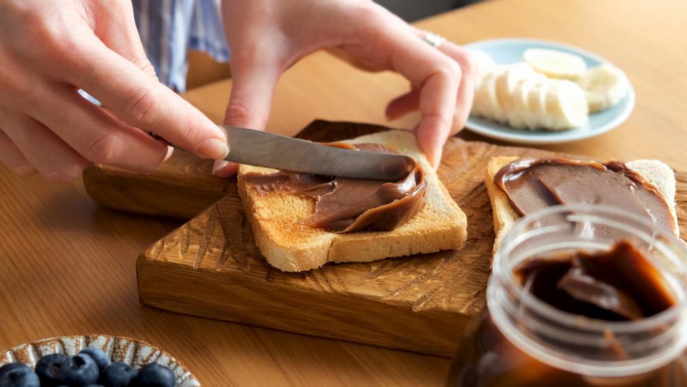 Person spreading Nutella on toast