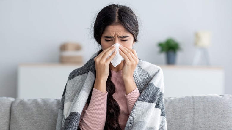 A woman blows her nose