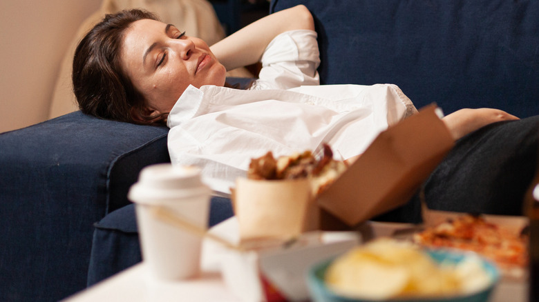 Woman lying on couch after eating