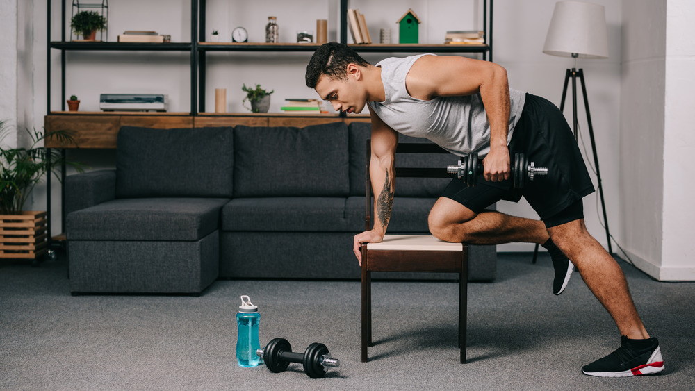 man using chair to lift weights