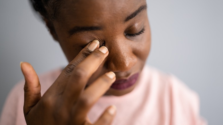 Woman touching her eyelid