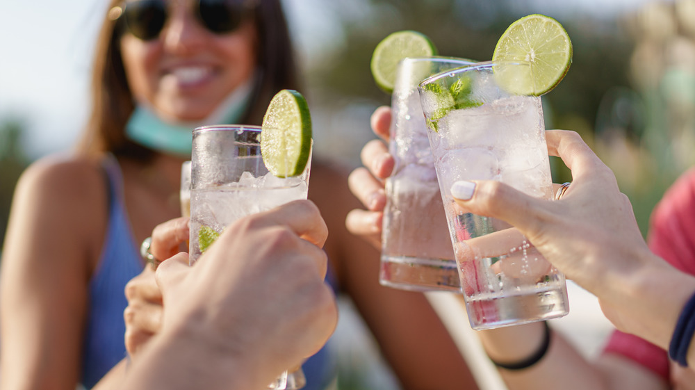 Clinking drinks with lemon and lime garnish