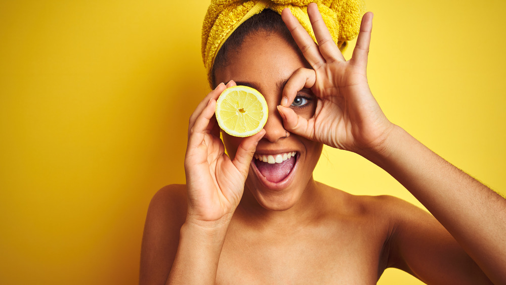 woman in hair wrap holding lemon