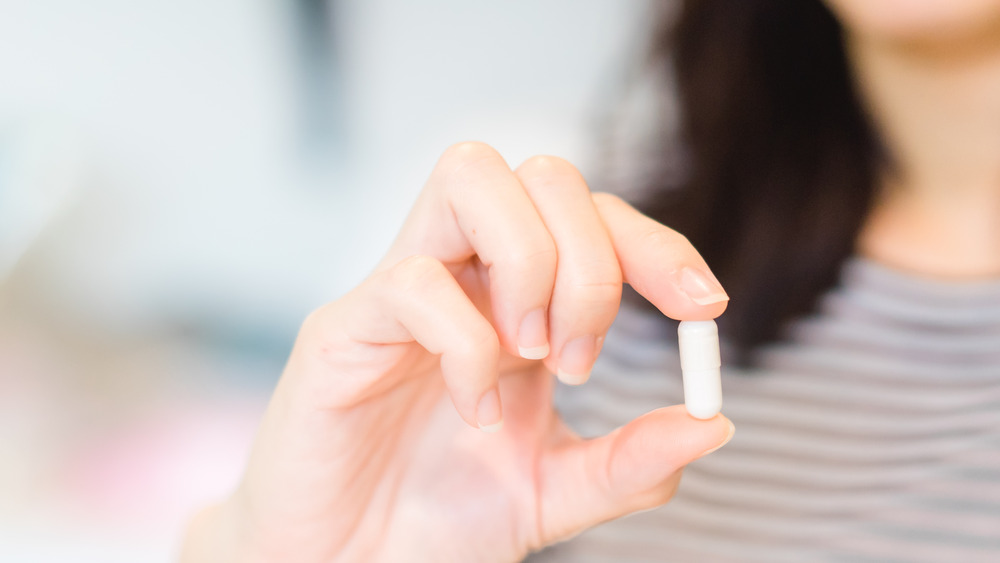 Woman holding a vitamin supplement