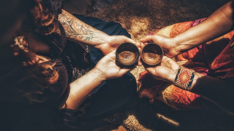 hands holding bowls of cacao 