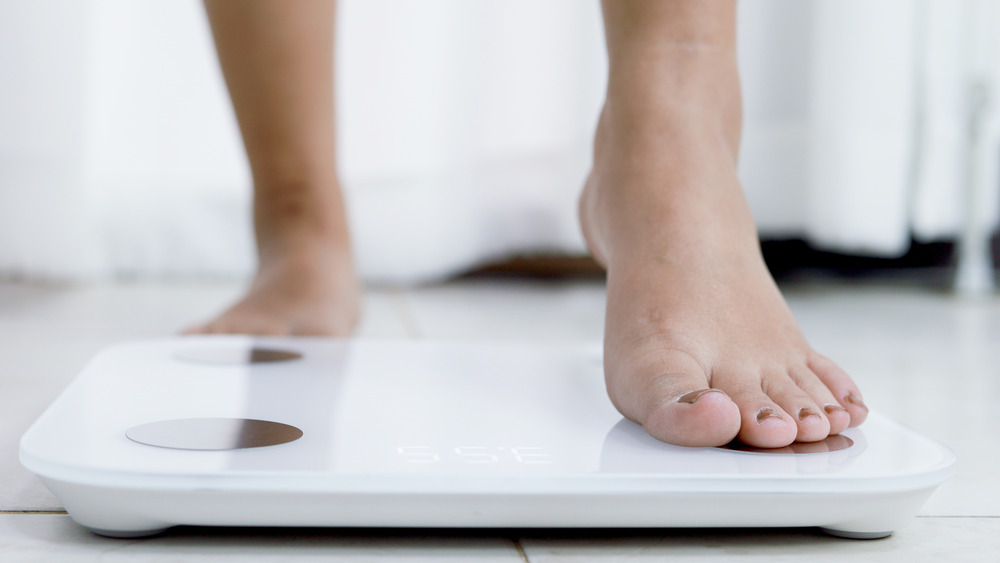 Close up of woman's feet stepping on a scale