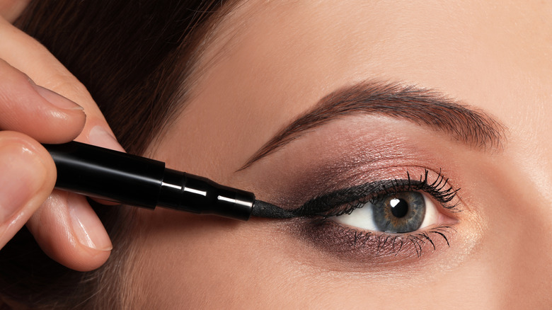 Woman applying eyeliner