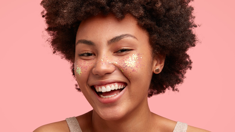 Smiling woman with glitter on face