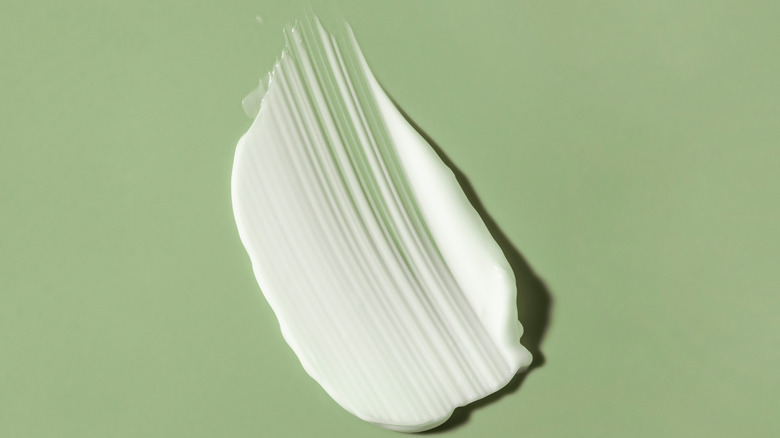 a swipe of sunscreen on a light green background 